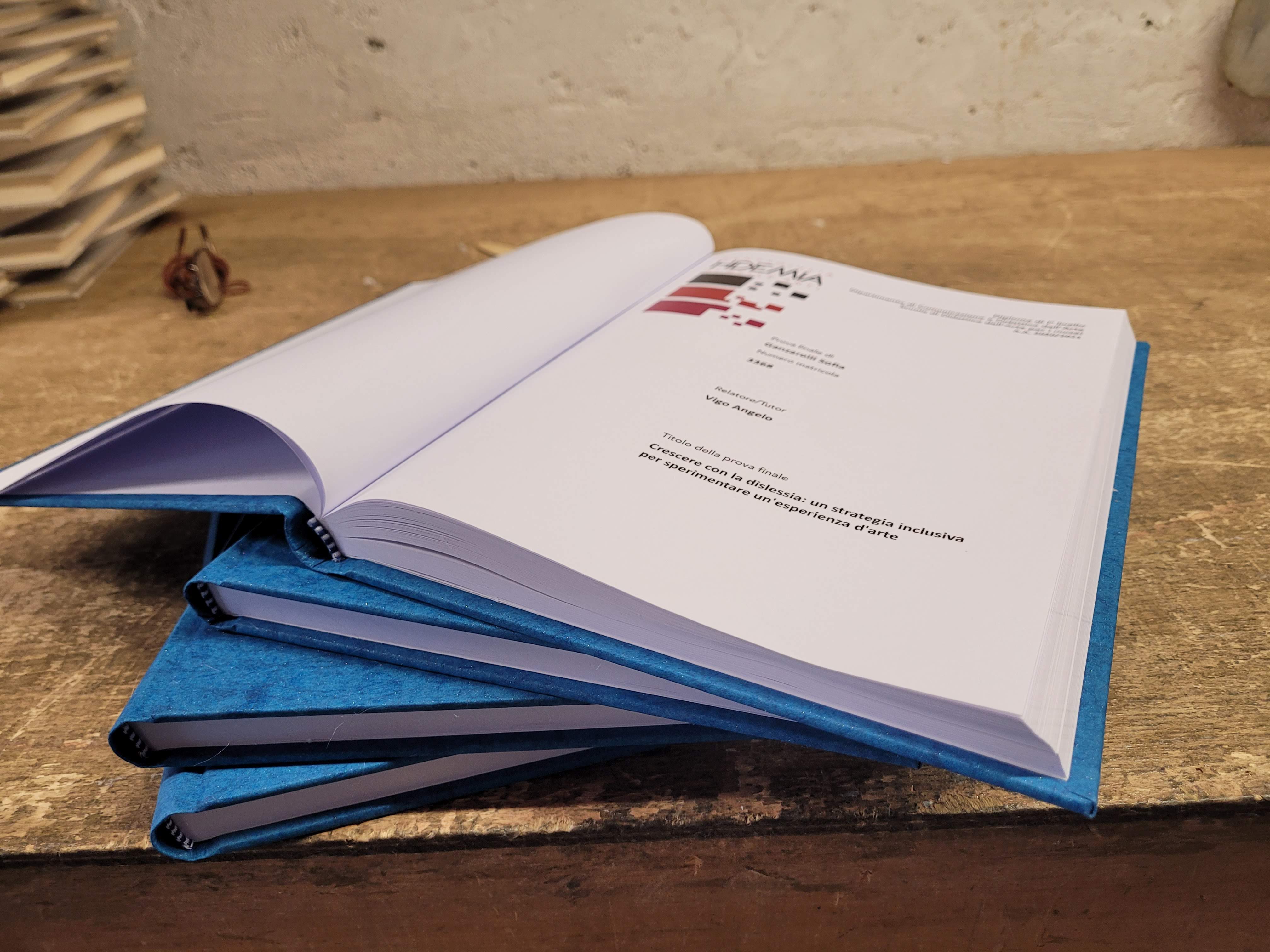 Tesi di laurea rilegata in blu con copertina rigida